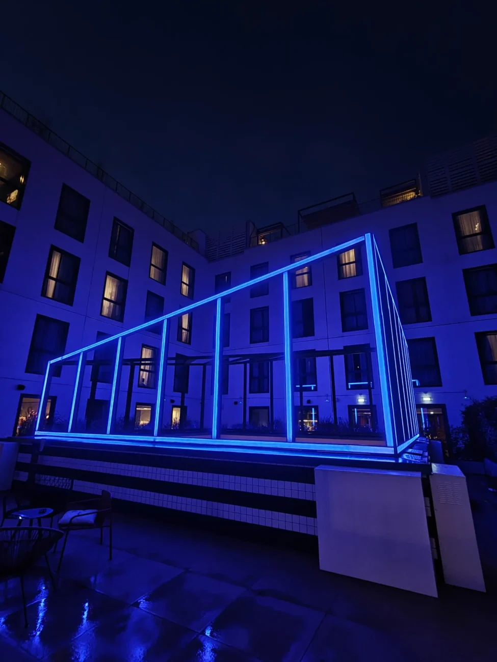 Un anno di pistakkio al the social hub florence belfiore 7 Cortile interno dell'area membership del the social hub florence belfiore con installazione luminosa blu geometrica. Foto originale di fabrizio gabrielli, seo expert, fondatore di agenzia seo pistakkio, firenze.